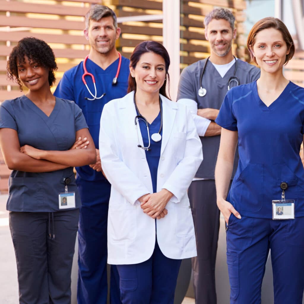 Healthcare team with ID badges stand outdoors